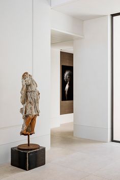 a sculpture is in the middle of an empty room with white walls and flooring