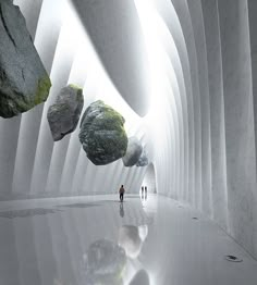 two people are walking through a tunnel with rocks and boulders on either side, while another person is standing in the distance