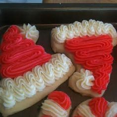 red and white frosted heart shaped cookies in a baking pan on top of a table