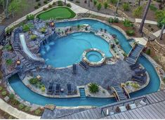 an aerial view of a swimming pool surrounded by trees