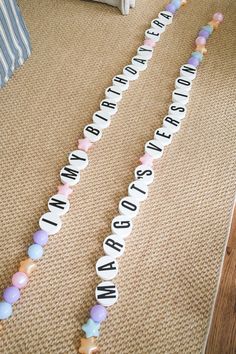 two baby name garlands on the floor in front of a bed with a teddy bear