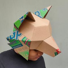 a young boy wearing a paper animal mask