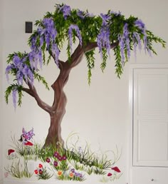 a tree painted on the side of a wall with purple flowers and green leaves in front of it