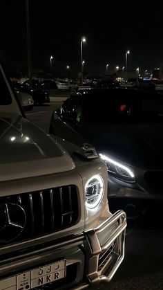 several cars parked in a parking lot at night