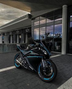 a black and blue motorcycle parked in front of a building