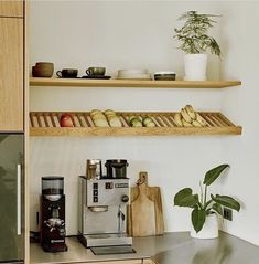 some food is sitting on the shelves above the coffee maker and other items in the kitchen