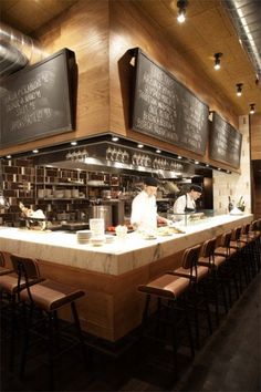 a restaurant with menus hanging on the wall and chairs in front of the counter