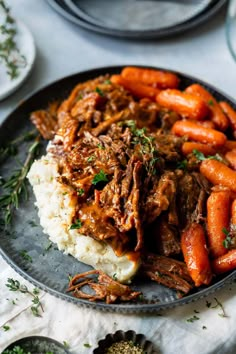 a plate with meat, carrots and mashed potatoes