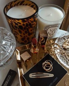 a table topped with candles and jewelry on top of a counter next to a mirror