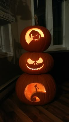 three pumpkins with faces carved into them