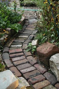 an image of a stone path in the garden with flowers and plants around it on instagram