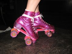 a close up of a person riding roller skates on a surface with pink shoes