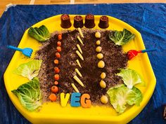 a child's birthday cake made to look like a vegetable garden with the word veggie spelled out on it