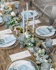 the table is set with blue napkins and place settings for two people to sit at