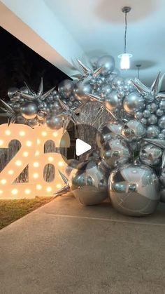 a bunch of balloons that are sitting on the ground in front of a sign with numbers