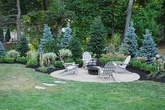 an outdoor patio with chairs and fire pit surrounded by trees