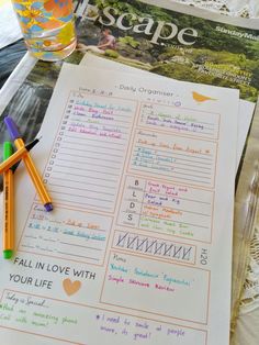 a couple of pencils sitting on top of a table next to a paper with writing