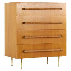 a wooden dresser with four drawers and brass legs