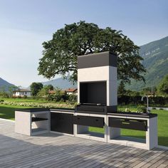 an outdoor bbq grill on a deck with mountains in the background