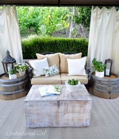 an outdoor living room with couches and potted plants