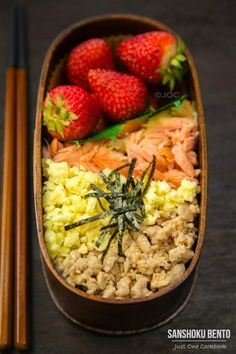 there are strawberries and other foods in the bowl with chopsticks next to it