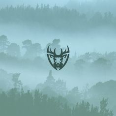 a deer head in the middle of a foggy forest