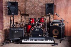 an assortment of musical instruments and amps in front of a brick wall