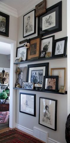 a wall with many framed pictures on it