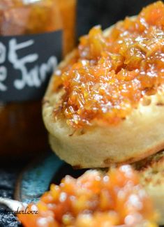 some food is sitting on a plate with a jar of jam in the back ground