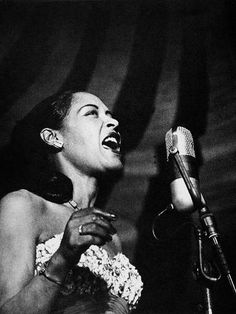 an old photo of a woman singing into a microphone