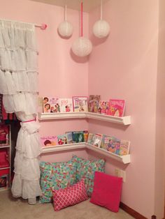 a bedroom with pink walls and shelves filled with children's books