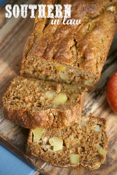 a loaf of banana bread sitting on top of a cutting board next to an apple