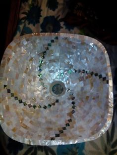 a bowl made out of mother of pearl beads