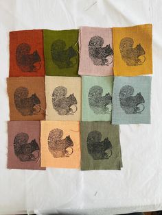 six different colored napkins with squirrel images on them, one is green and the other is red