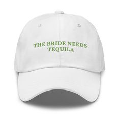 the bride needs tequila hat is white with green lettering on it that says,'the bride needs tequila '