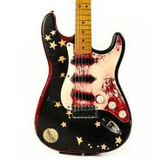 a red and black guitar with stars painted on it's body, sitting in front of a white background