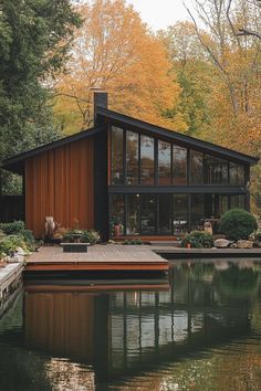 a house sitting on top of a lake surrounded by trees