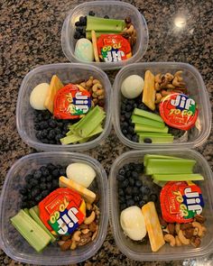 four plastic containers filled with food on top of a granite countertop next to a bottle of soda