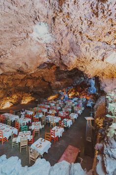 tables and chairs are set up in the cave for an outdoor dining party or gathering