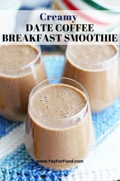 three glasses filled with smoothie sitting on top of a blue and white table cloth