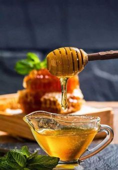 honey being drizzled into a glass tea cup with mint leaves on the side