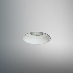 an image of a white ceiling light in the middle of a gray room with dim lighting