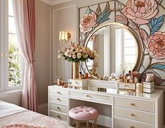 a bedroom with a large mirror, vanity and flowers on the wall