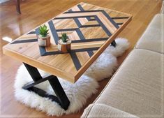 a wooden table sitting on top of a hard wood floor next to a white couch