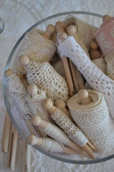 a glass bowl filled with knitted items on top of a white tablecloth covered floor