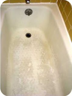 a bathtub filled with foam and water next to a tiled wall in a bathroom