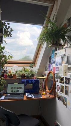 a desk with a laptop computer on top of it next to a window filled with pictures