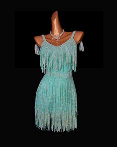 a mannequin wearing a dress with fringes and beads on the neckline