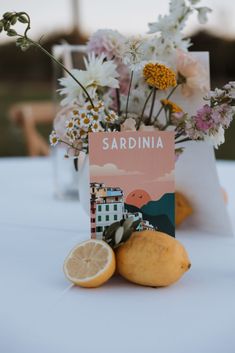 there is a vase with flowers and lemons on the table at this wedding reception