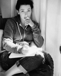 a woman sitting on a couch holding a pen and paper